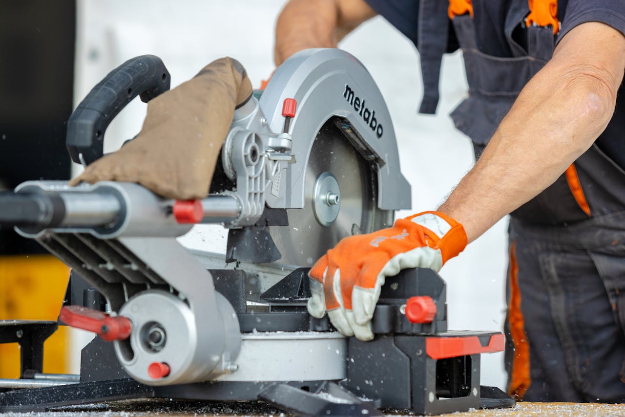 about-04 Focused worker using a metal saw for precise cutting at a construction site.